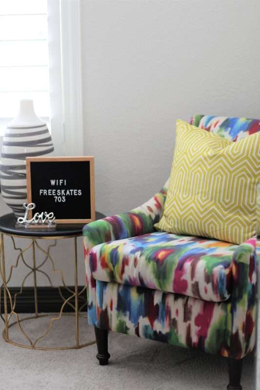 feminine guestroom, girl guestroom, guestroom, boutique style guest room, colorful guestroom, accent chair in guest room, black bed, wooden bed, floor mirror, textured bedding, guest bedroom decor