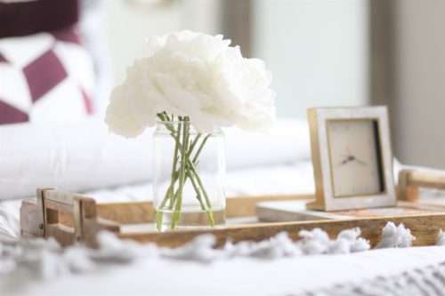 table books, books on coffee table, books on table, coffee table decor, how to accessorize like a pro, boxwood on table, mixing materials, coffee table accessories, accessorizing, how to accessorize, how to layer books, how to decorate like a pro, how to decorate with books, display case, agate stone, agate stone in display case, decorating in odd numbers, the rules of three, how to decorate in odd numbers, living room decor, mirrored credenza, balanced living room, luxury living room, mixed materials, vignette, floor lamp, brass floor lamp, navy sofa, navy sofa with chaise, pillow in basket, black basket, peonies, vases, silver vases, silver clay vases, wood tray, mixing metals