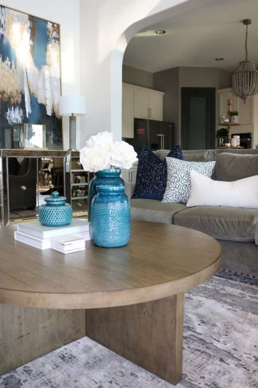blue accessories, blue decor, living room with blue decor, gray sofa, living room decor, living room, neutral living room, pops of blue, blue colors in living room, blue pillows, blue vases, wooden coffee table