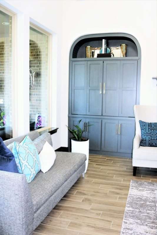 blue accessories, blue decor, living room with blue decor, gray sofa, living room decor, living room, neutral living room, pops of blue, blue colors in living room, blue pillows, blue vases, wooden coffee table